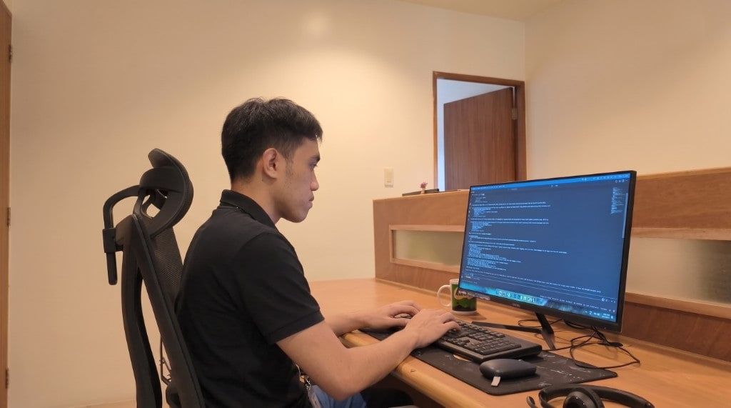 Yoonet teammate coding at his workstation in the Balanga office